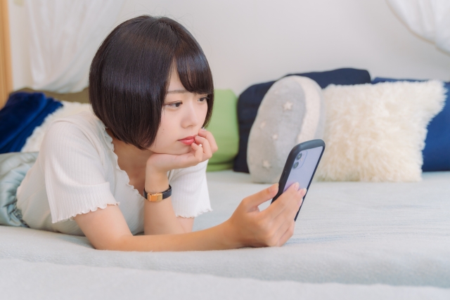 女性がスマホを見ている写真