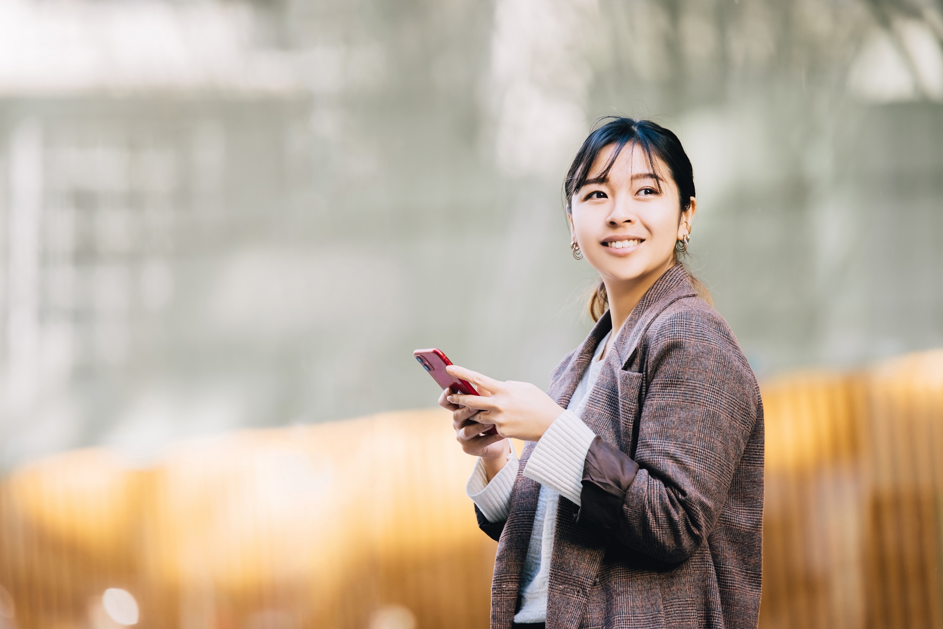 女性がスマホを操作して、振り返る写真