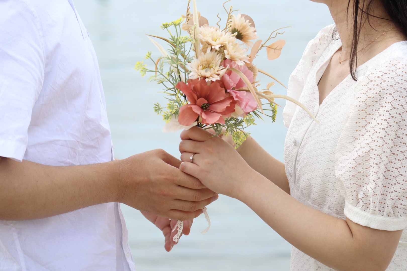 男性が女性に花束を渡している写真